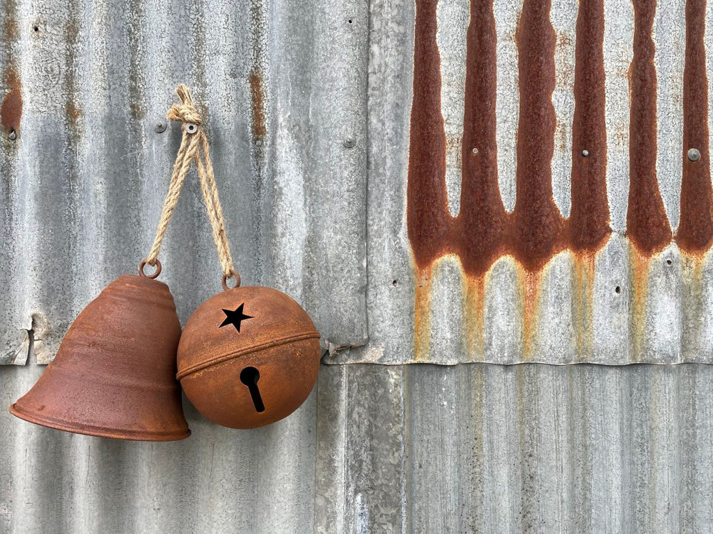 The Twig and Feather rustic country Christmas collection - showing 2 rusty bells on a metal wall
