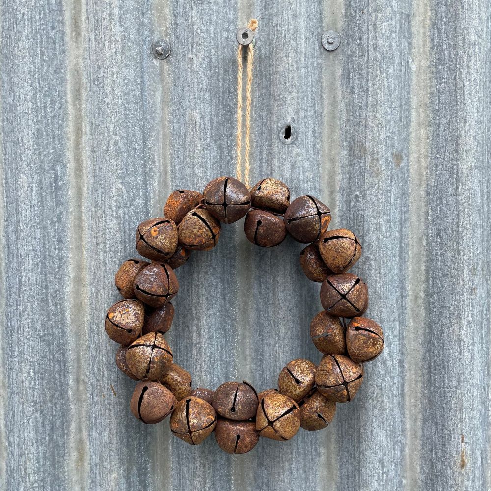 Wreath made of brown bells hanging on a corrugated metal wall
