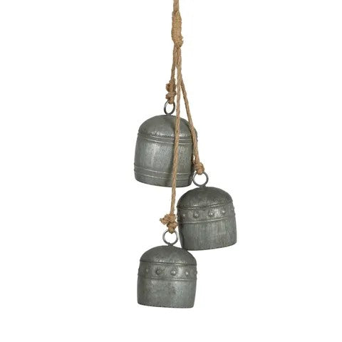 Three grey iron bells in different sizes hanging from a rope on a white background