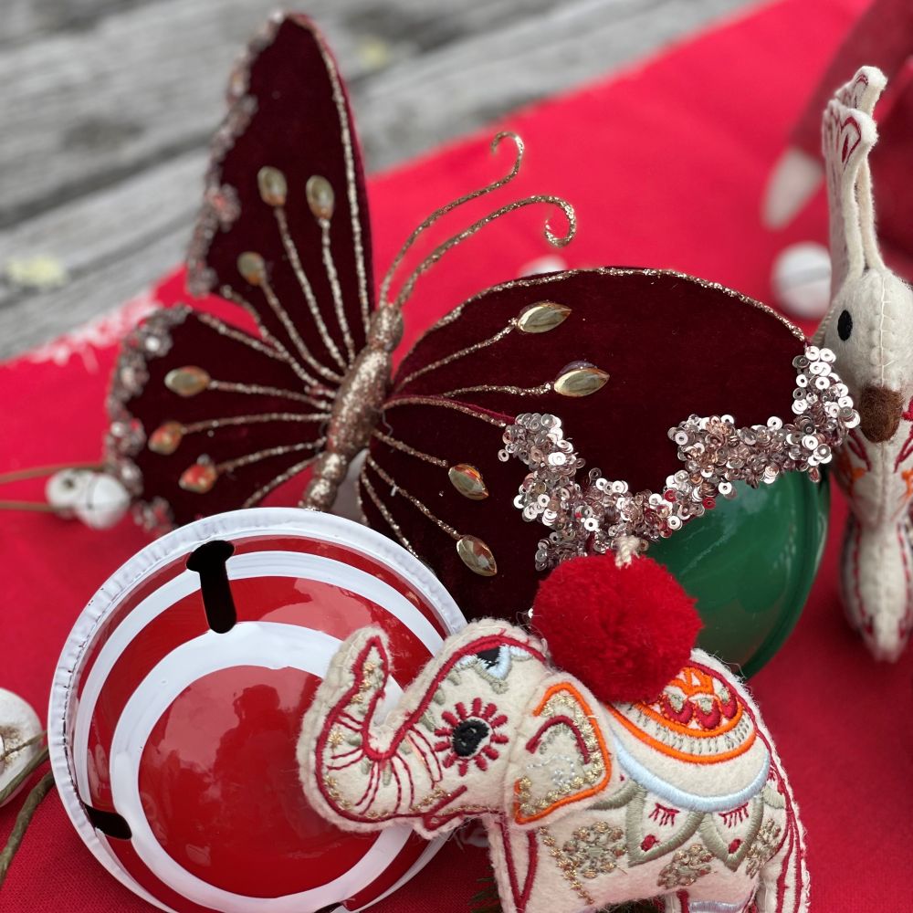 Carnival Christmas table arrangement featuring red table runner and elephant, bird, butterfly and candy stripe red and white bauble