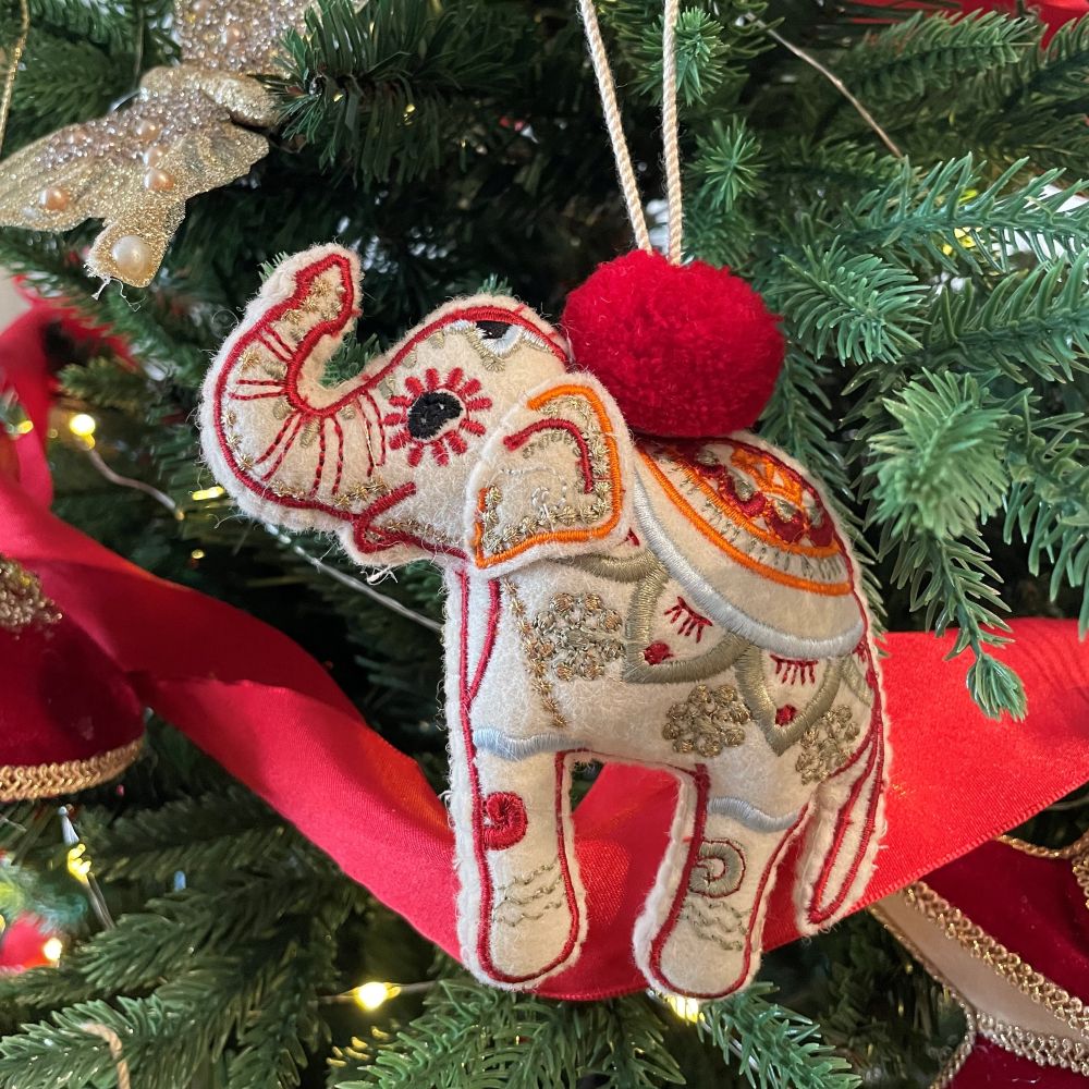 Decorative elephant ornament with red pom-pom on a Christmas tree