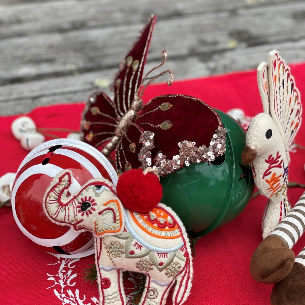Carnival Christmas table arrangement featuring red table runner and elephant, bird, butterfly and candy stripe red and white bauble