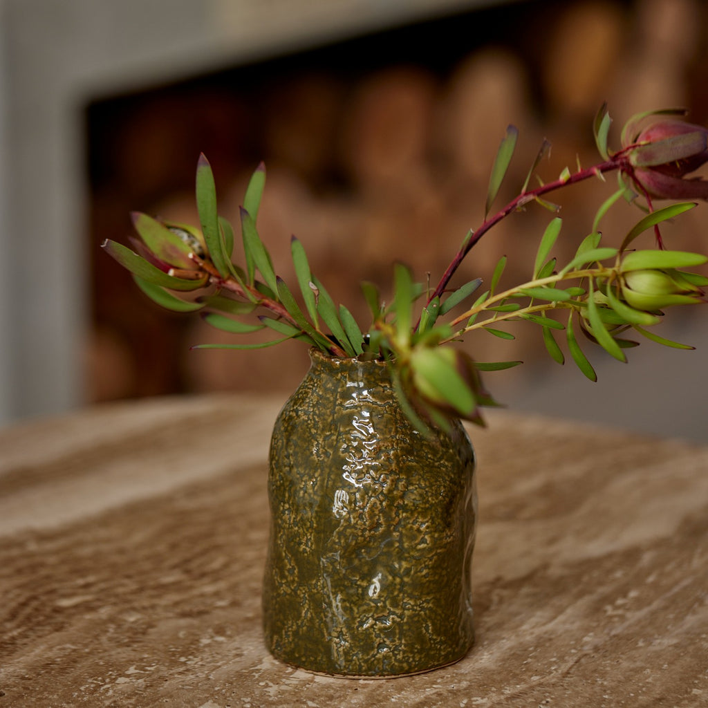 Twig and Feather: Olive Green ceramic vase with a plant on a textured surface - by Madras Link
