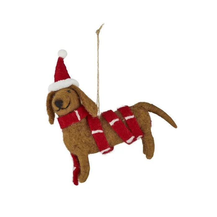 Brown felt dog with red and white scarf and hat hanging on a white background