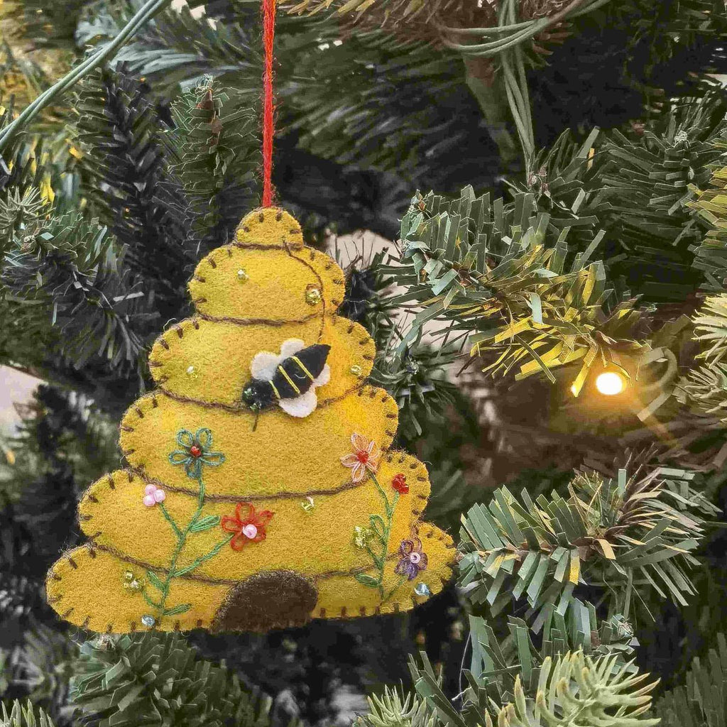 Yellow beehive ornament with a bee on a Christmas tree.
