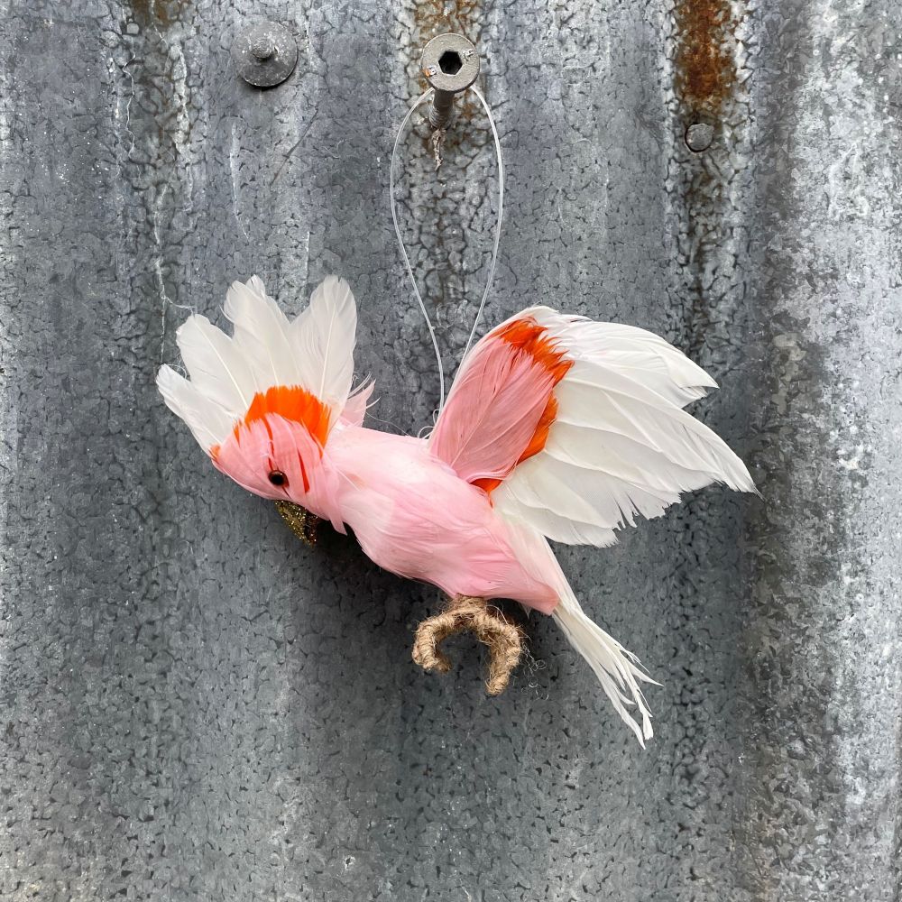 Decorative Major Mitchell Cockatoo flying feathered bird ornament on a textured metal surface