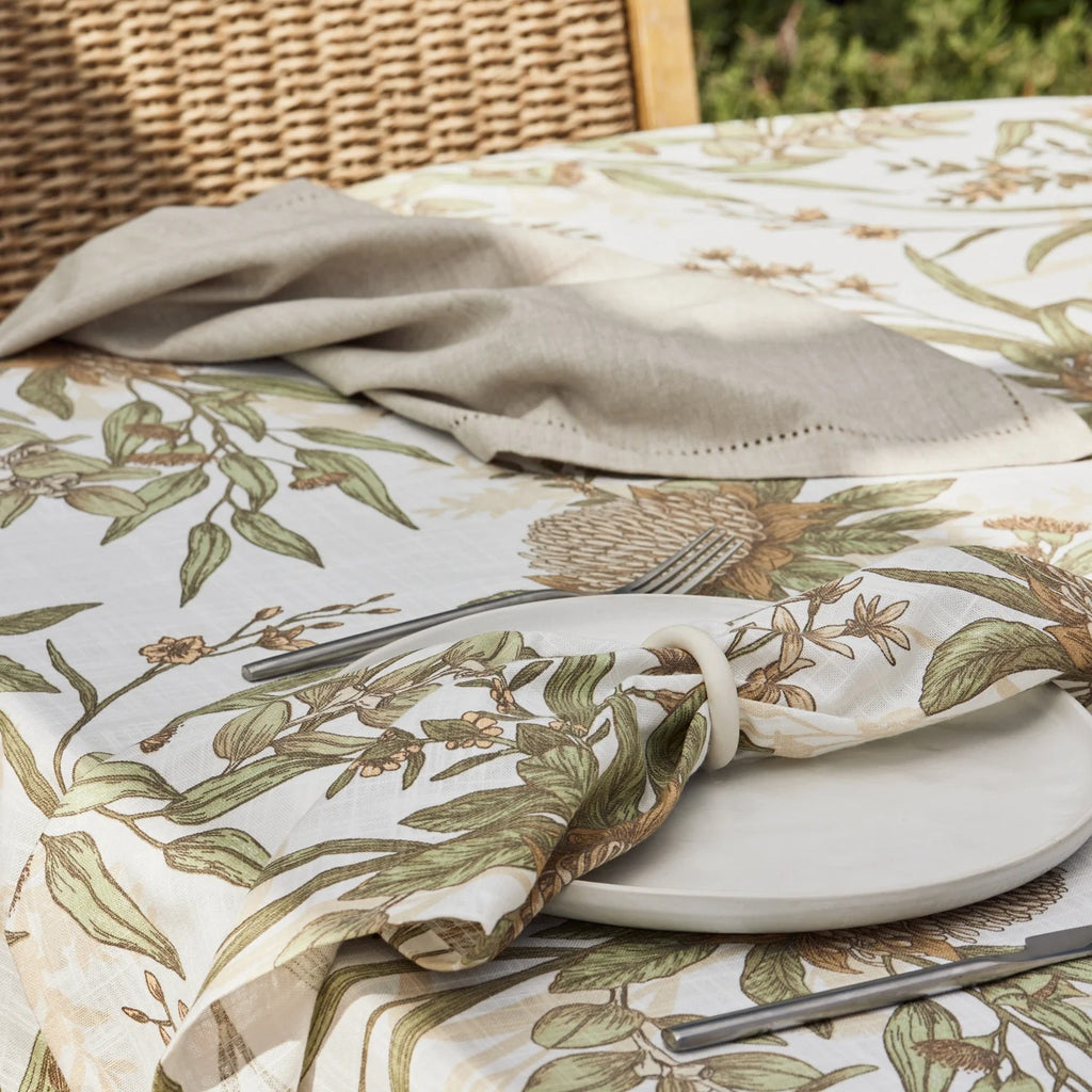 Table setting with native floral napkins and tablecloth styled on table