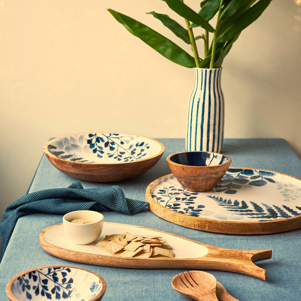 Tableware with blue floral patterns on a blue tablecloth.