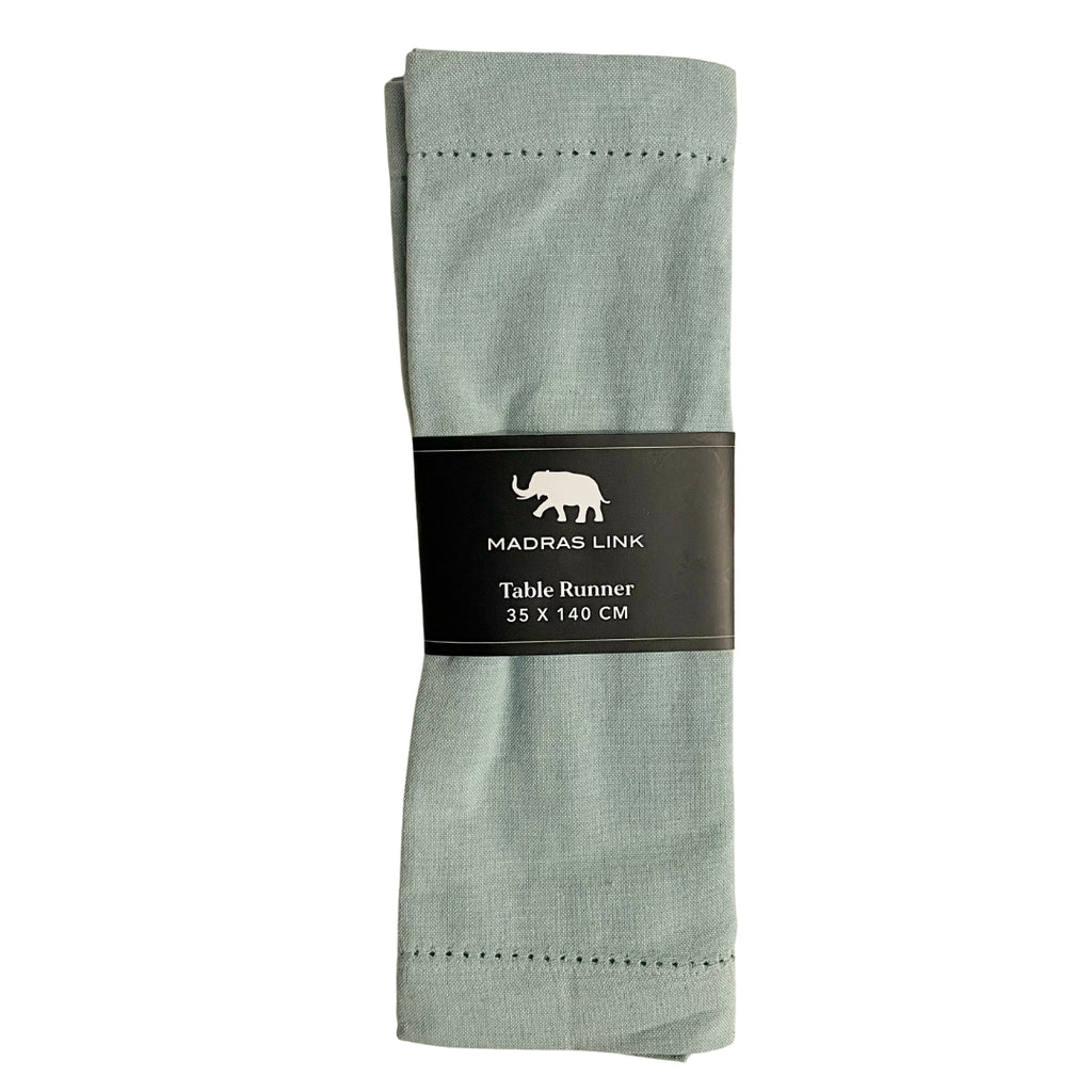 Folded sky blue table runner with a label on a white background
