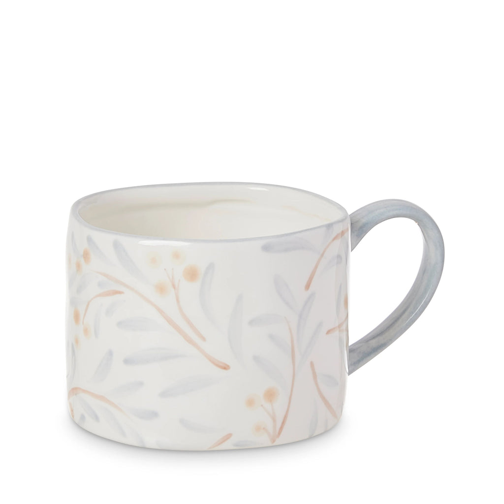 Juniper White mug with subtle berry and leaf pattern in blue and apricot on a white background