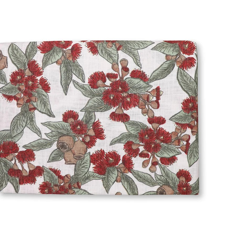 Australian flowering gum red table runner depicting red flowers, gumnuts and green leaves on a white background