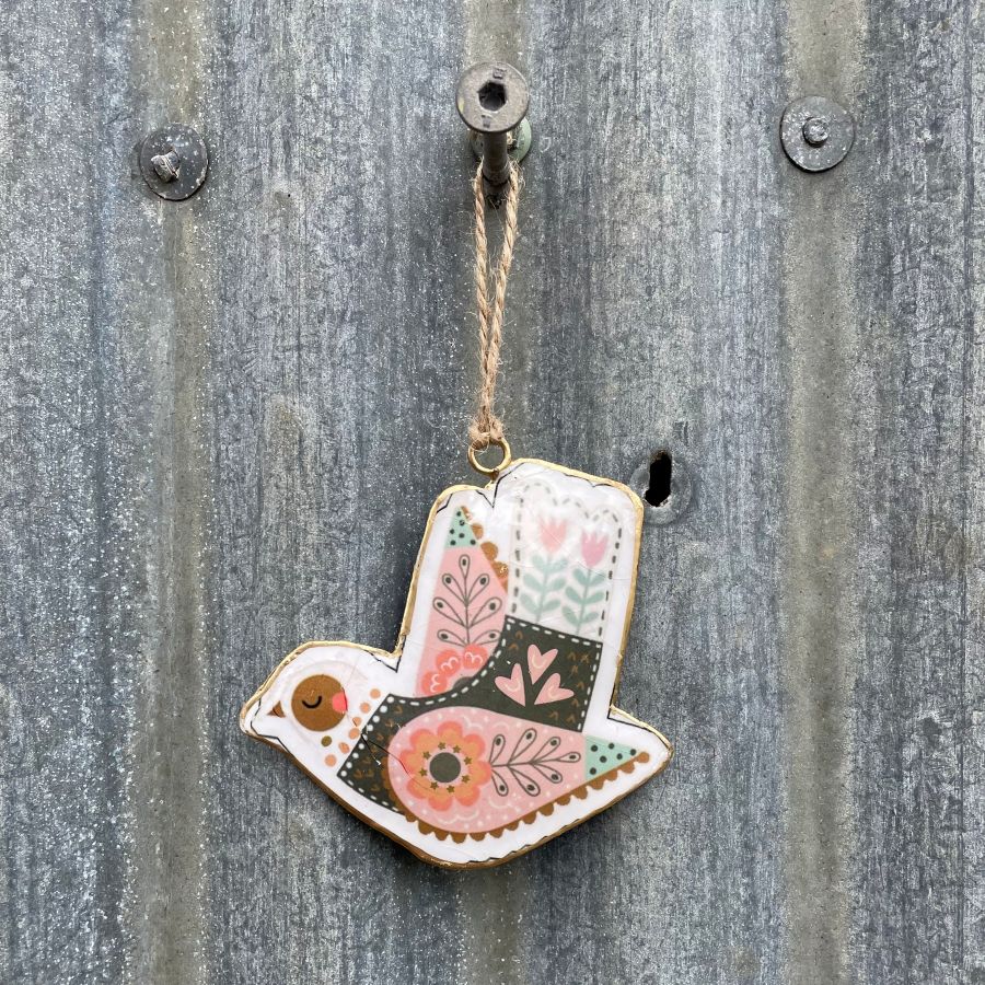 Decorative bird ornament with floral nordic patterns on a corrugated metal wall background