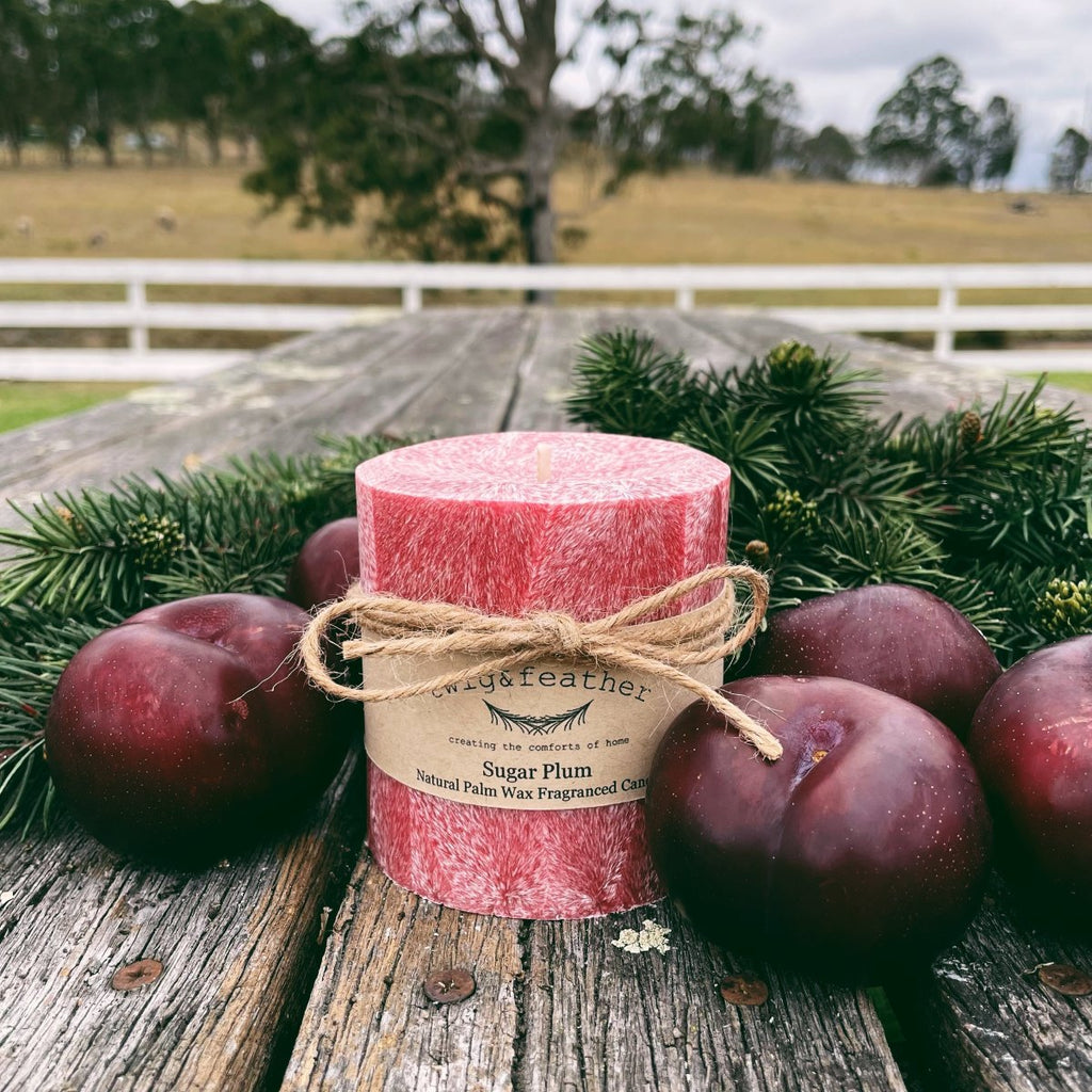 Twig and Feather Sugar Plum red palm wax candle 38 hours surrounded by plums and christmas branches