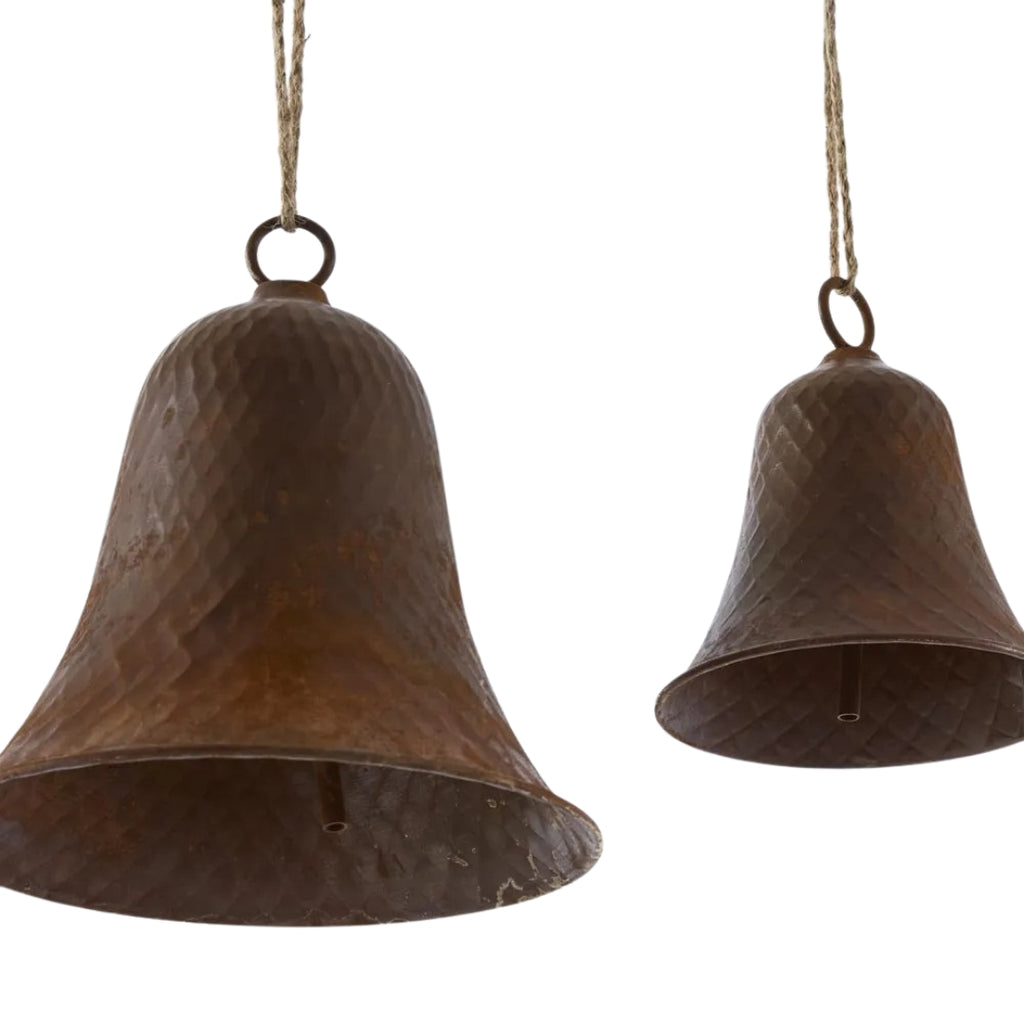 Two rusty bells hanging on strings against a white background