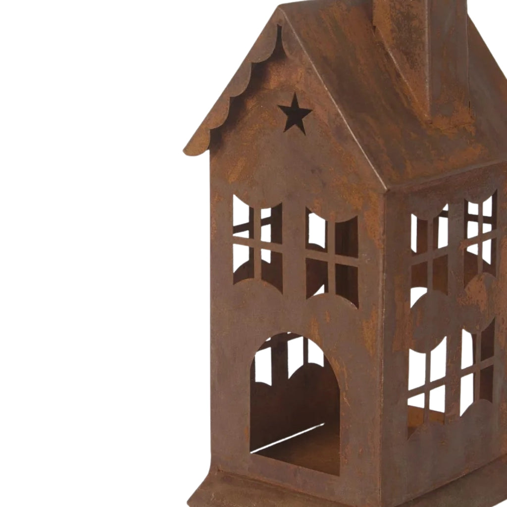 Rusty metal lantern or candle holder in house design on a white  - detailed view