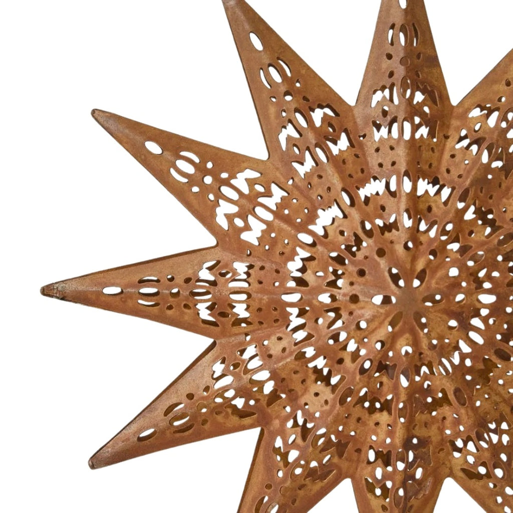Decorative rusty etched star-shaped ornament with cut-out patterns on a white background - detailed view