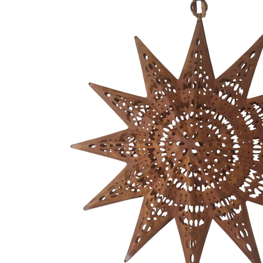 Decorative rusty etched star-shaped ornament with cut-out patterns on a white background 