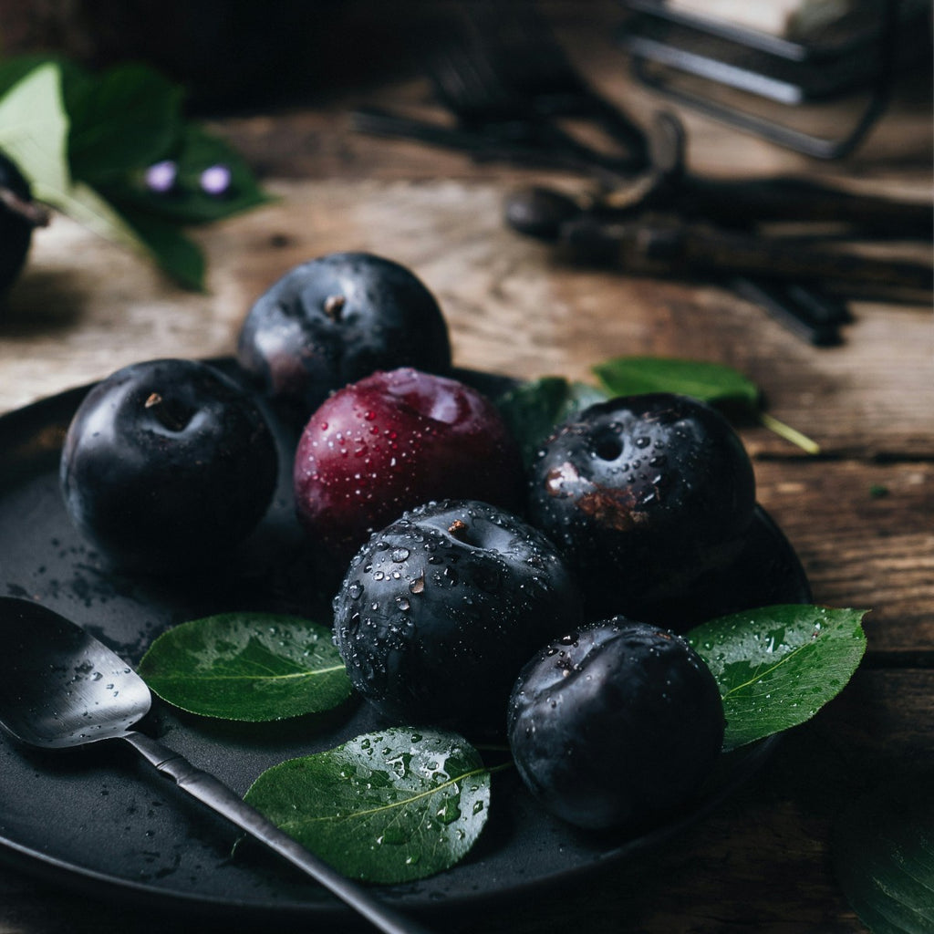 Plums on a plate with moisture droplets