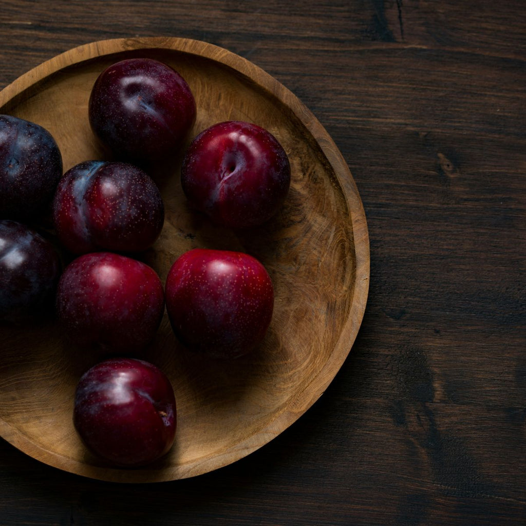 Plums on a wooden plate