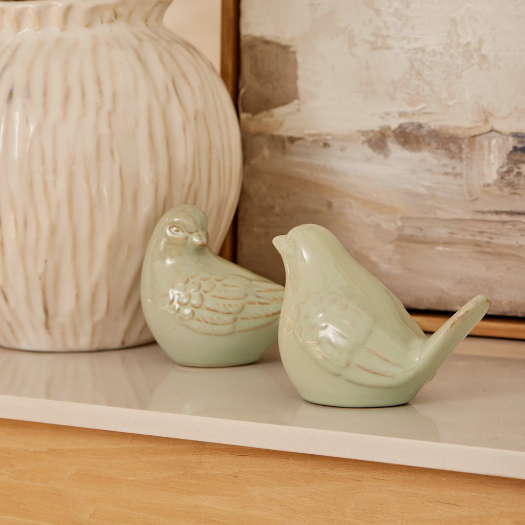 Twig and Feather - Two sage green ceramic birds on a shelf with a textured wall print in the background - by Madras Link