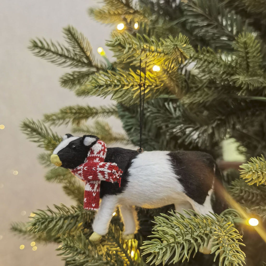 Christmas cow ornament with a red scarf on a Christmas tree
