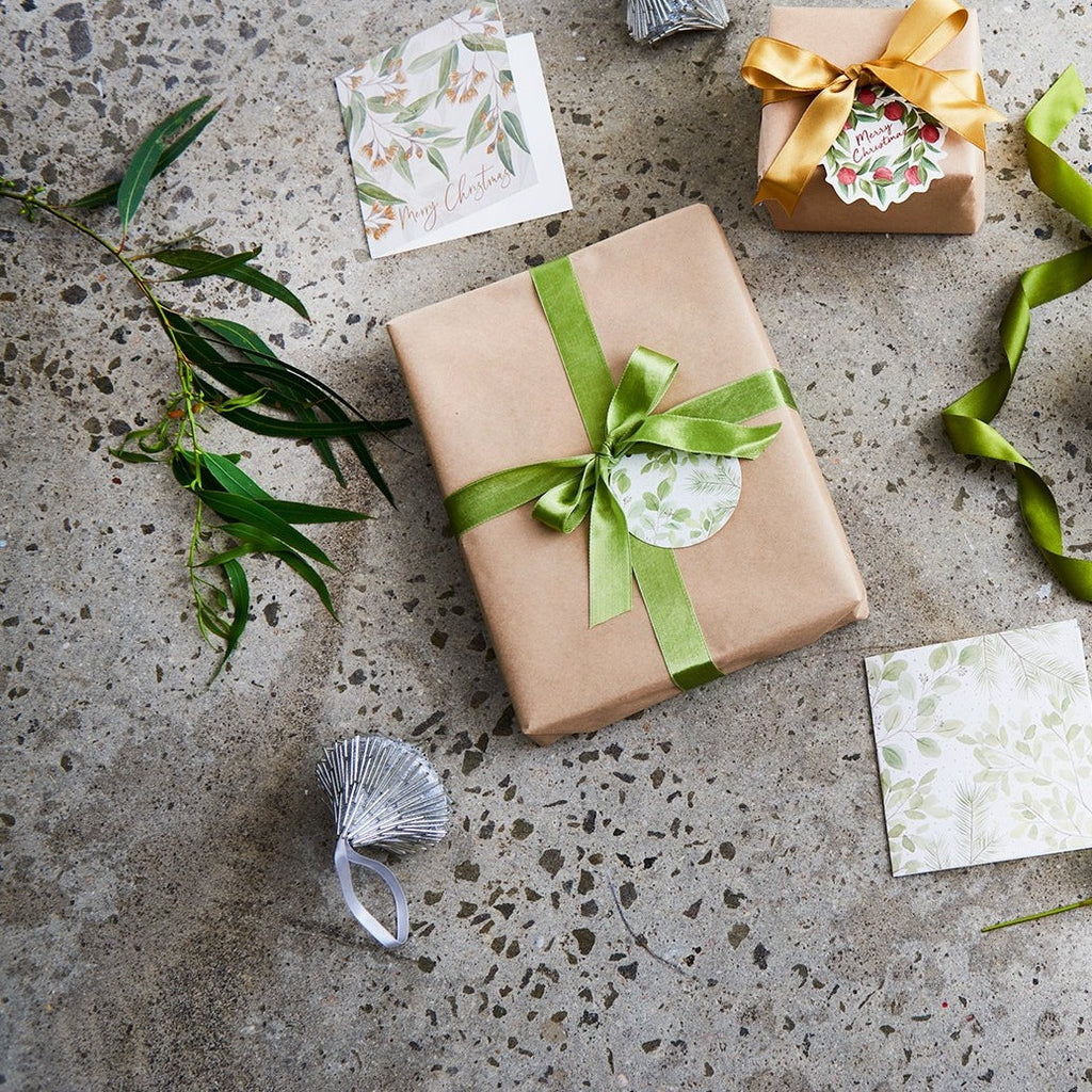 Christmas theme - Gifts wrapped in brown paper with a green ribbon on a concrete surface.