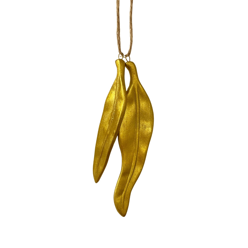 Gold leaf-shaped Christmas decoration on a white background