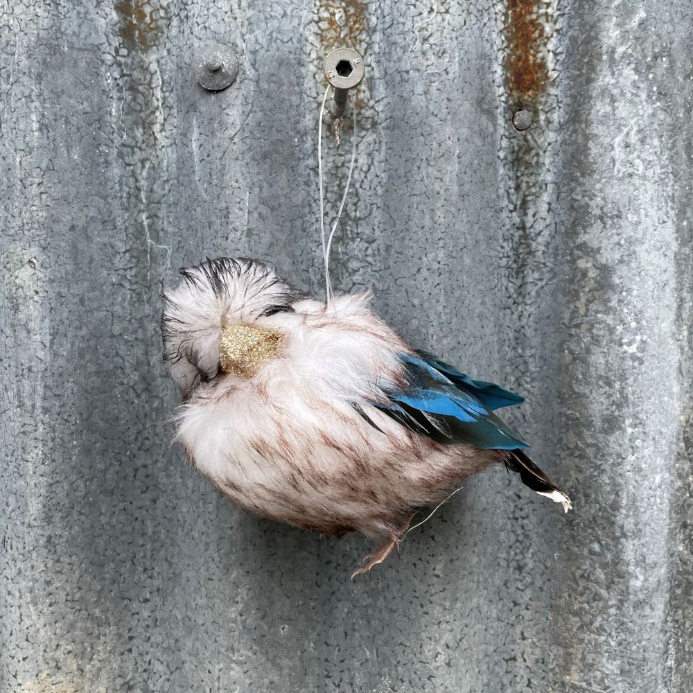 Decorative Australian Kookaburra ornament made of feathers on a textured metal surface