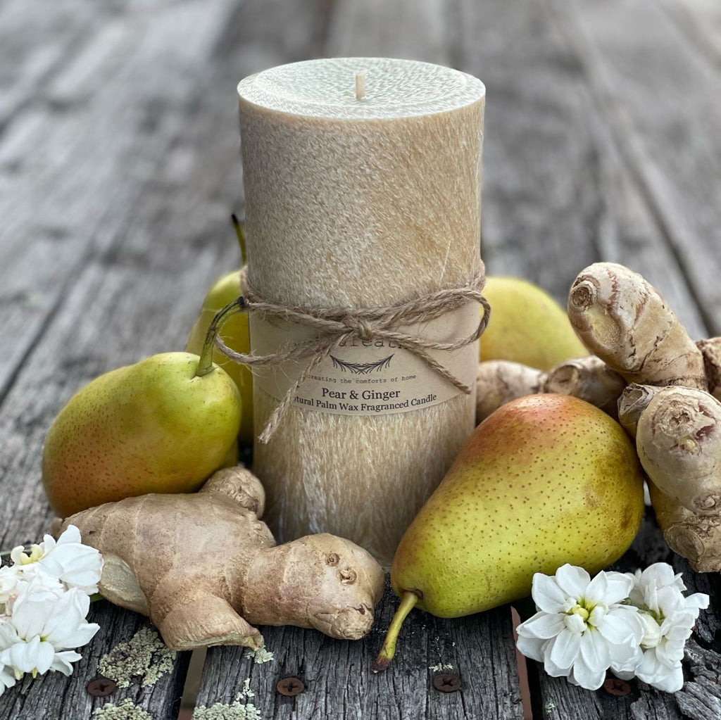 Twig and Feather Pear & Ginger Palm wax pillar 80 hour Candle wrapped in label and twine with pears and ginger on a wooden surface