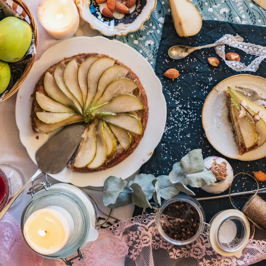 Pear tart on a decorative table with candles  - evokes the feeling of the pear and ginger fragrance