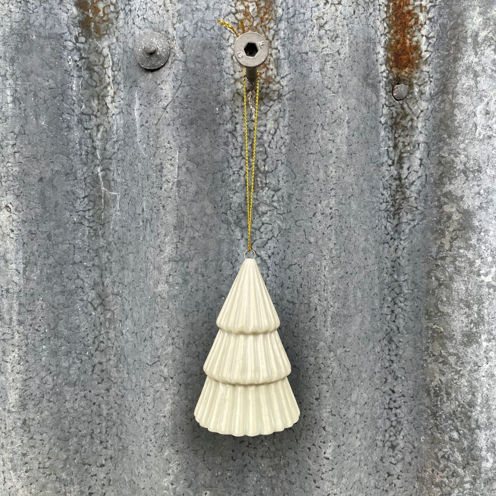 Ceramic tree hanging decoration in soft sage green against a textured metal background