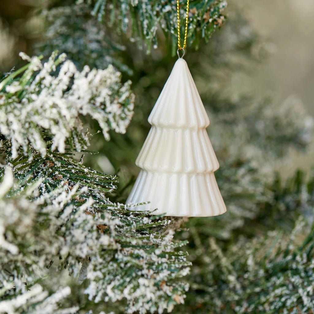 White Ceramic Christmas tree ornament hanging on a decorated tree