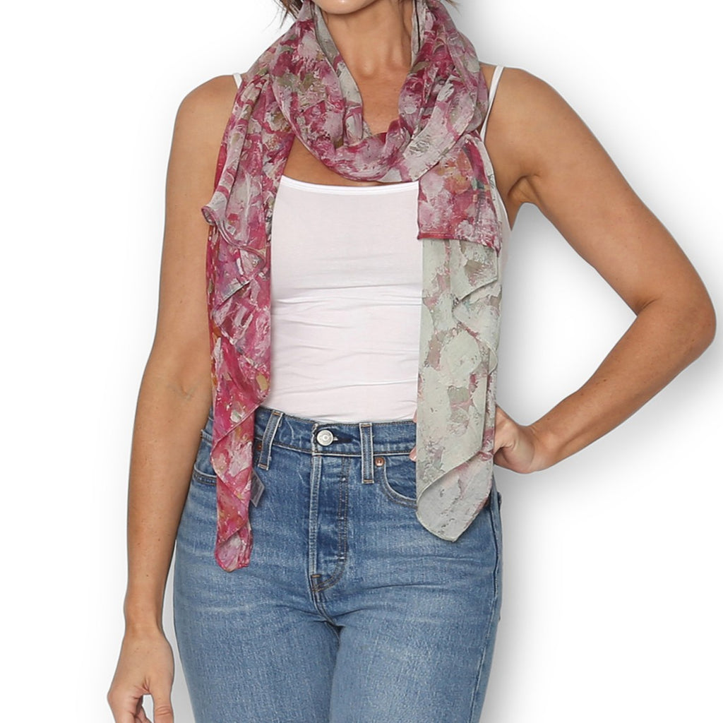 Woman wearing The Artist Label Pink Primrose patterned scarf, in shades of pink with hints of gold and blue.