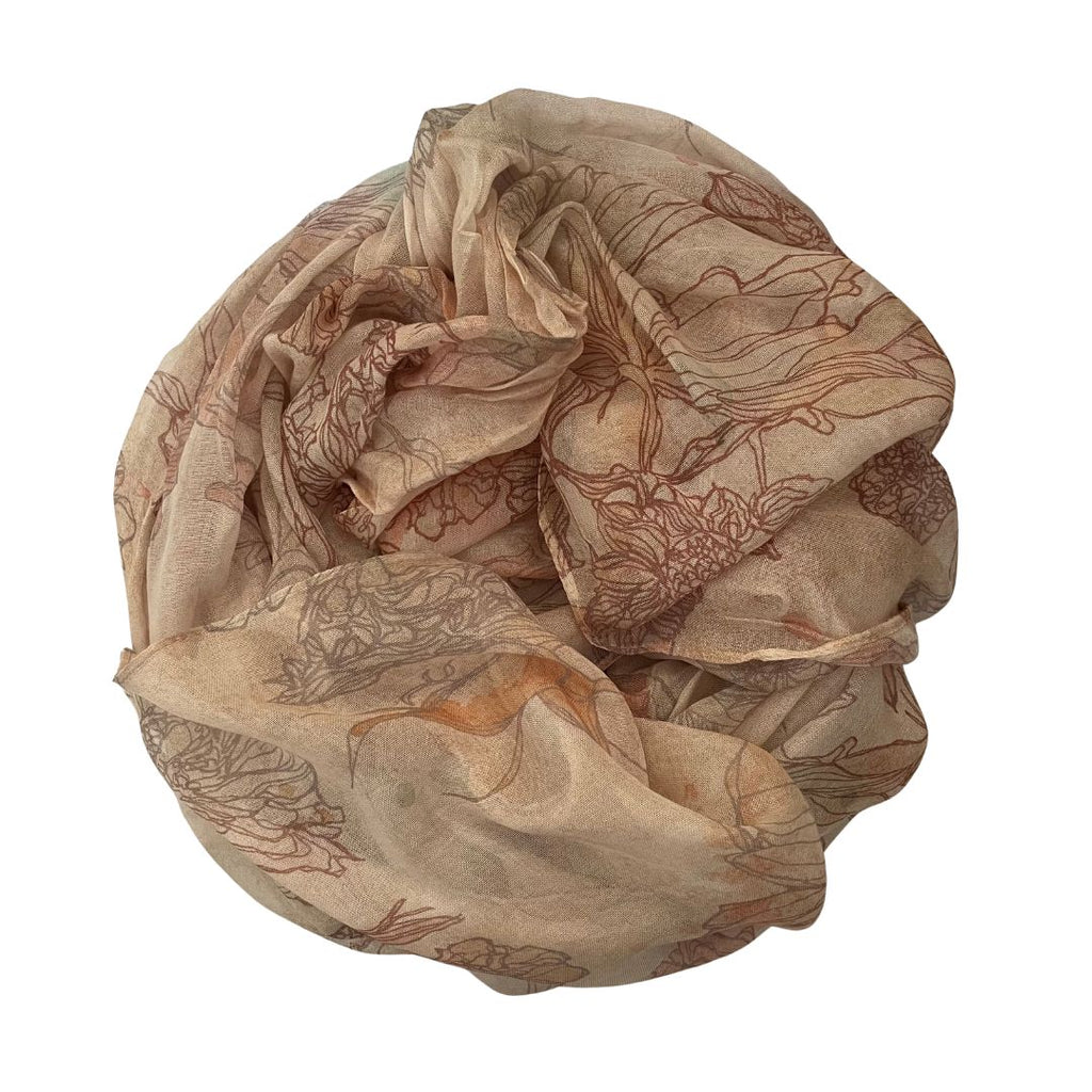 The Artist Label Nature's Tapesty scarf with beige floral patterns rolled up on a white background