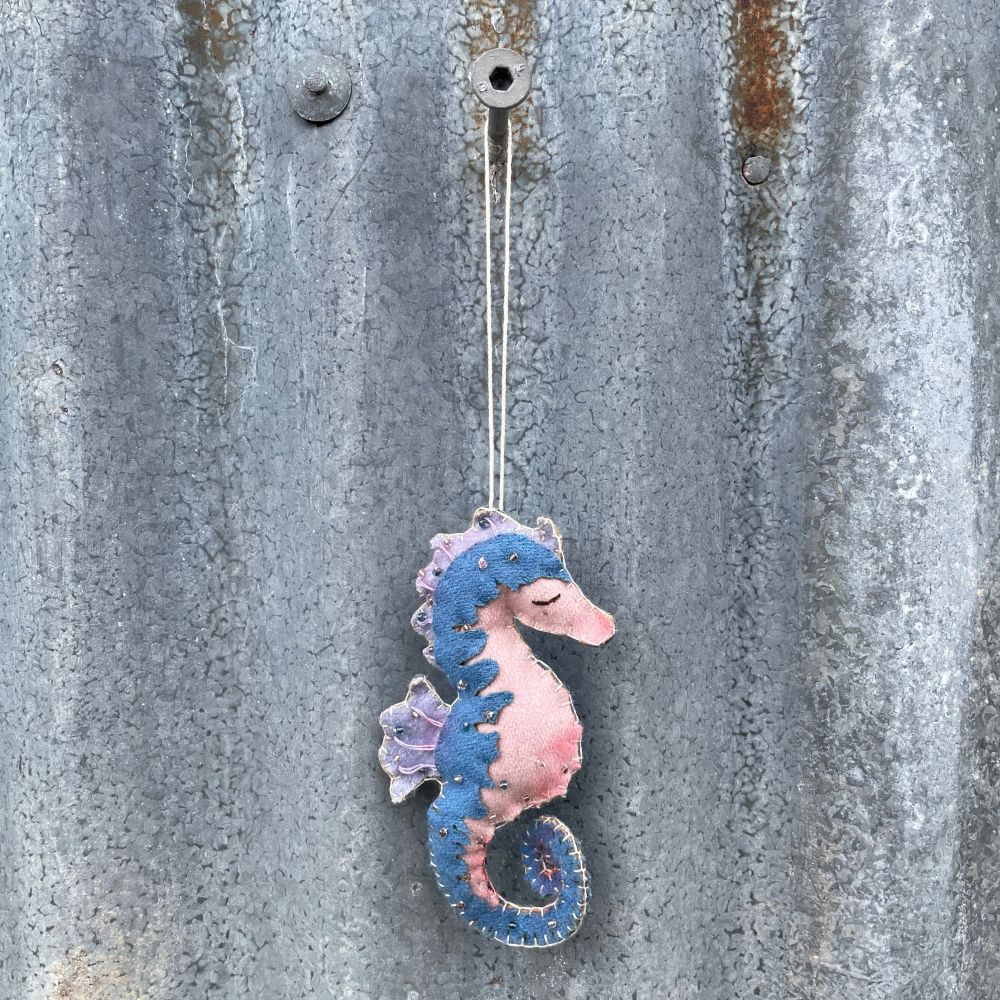 Decorative seahorse hanging on a textured metal surface