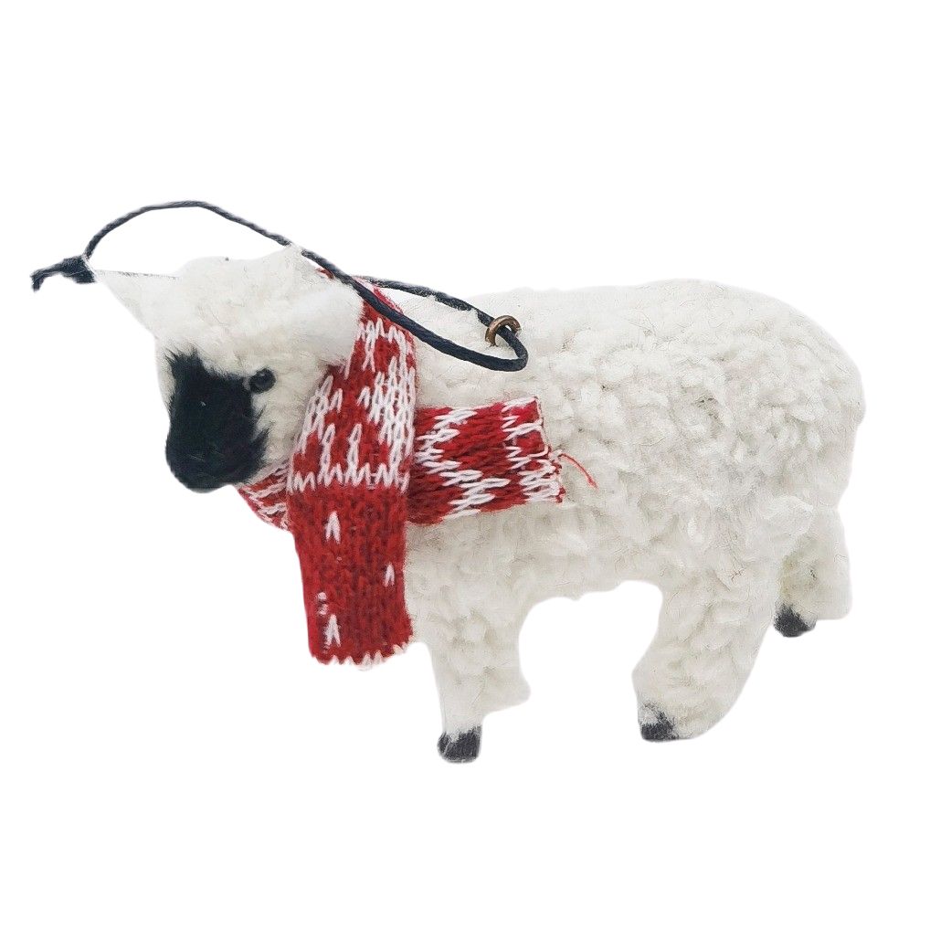 White sheep ornament with a red and white patterned scarf on a white background