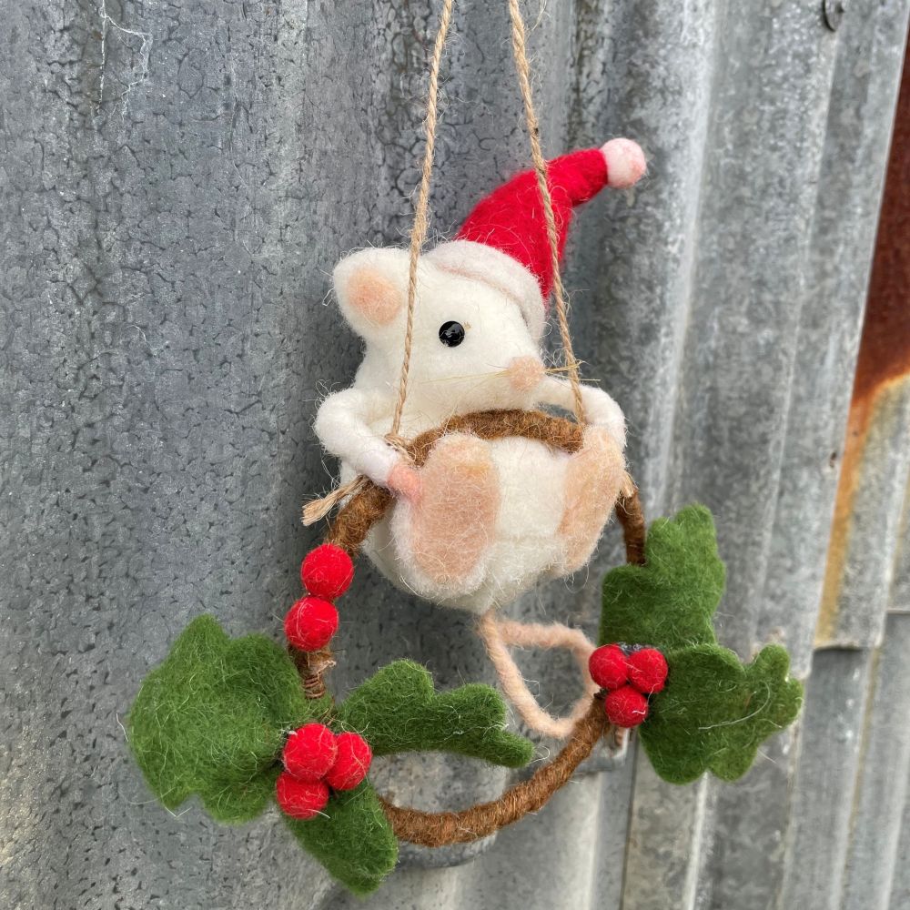 Felted mouse ornament with Santa hat on a wreath against a metal background