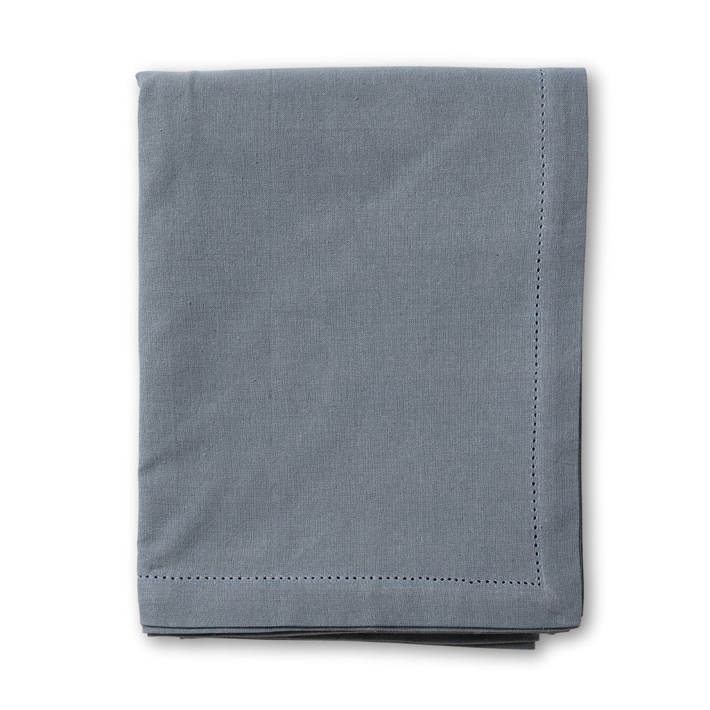 Folded mineral blue tablecloth on a white background