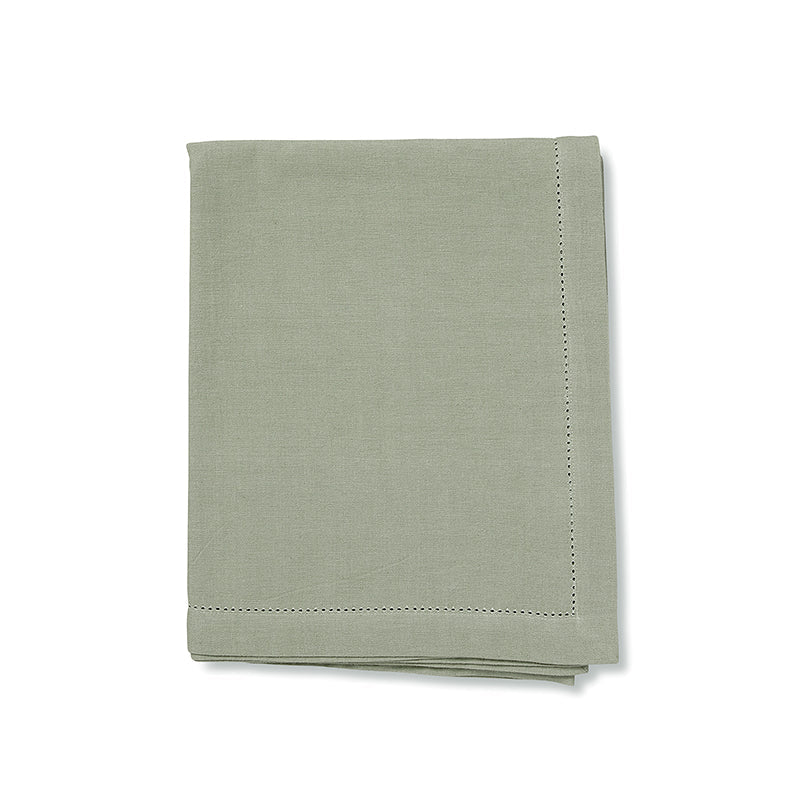 Folded mineral green tablecloth on a white background