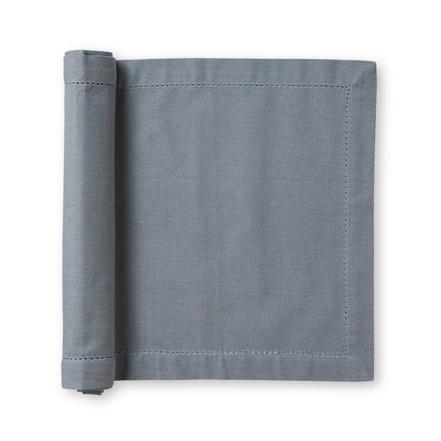 Rolled up mineral blue table runner on a white background