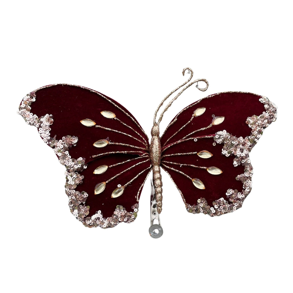 Decorative velvet burgandy butterfly with gold embellishments on a white background