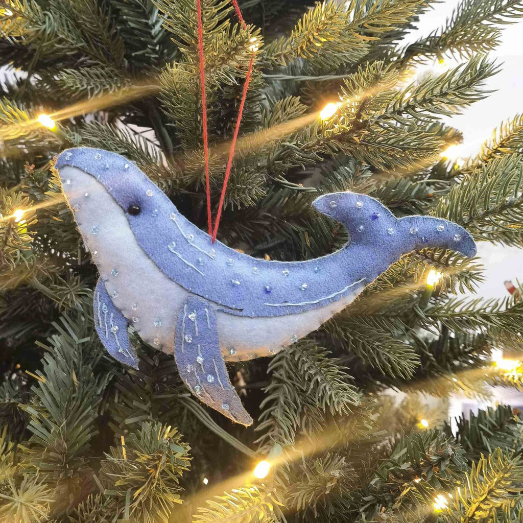 Blue felt whale ornament on a decorated Christmas tree