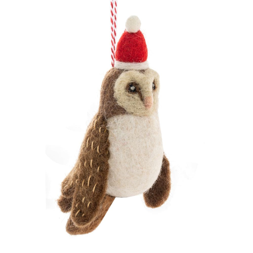 Hanging felt barn owl ornament wearing a red Santa hat on a white background