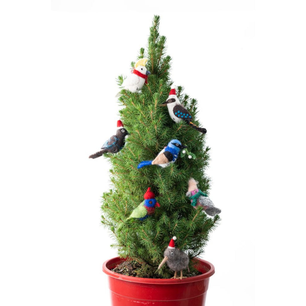 Small potted Christmas tree with felt bird decorations on a white background