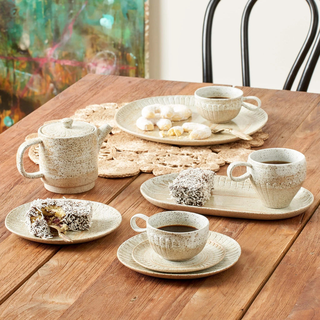 Twig and Feather - Celyon cup and saucer set with brown speckled glaze on white and taupe ceramic, and slight pattern indentation - by Robert Gordon - shows more of the range