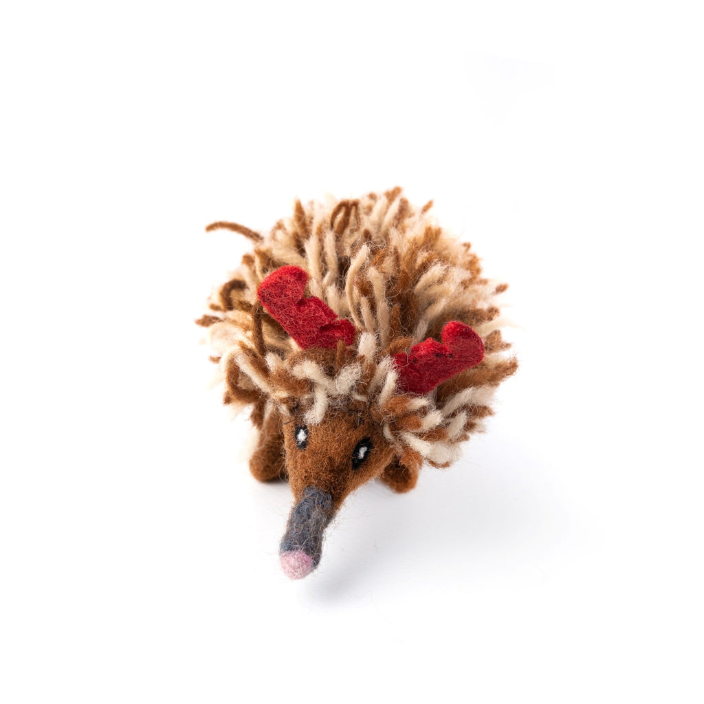 Felted echidna ornament with red antlers on a white background