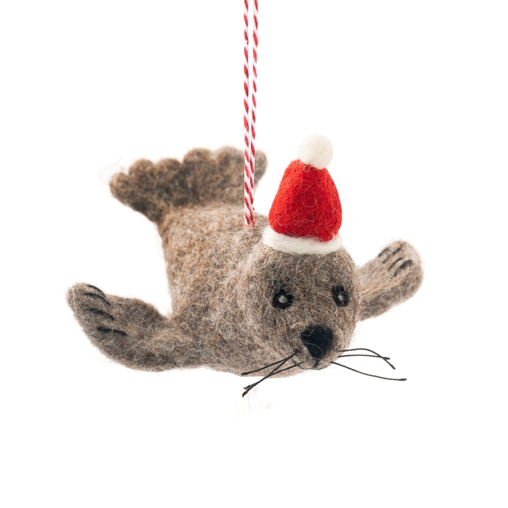 Felted seal ornament wearing a Santa hat on a white background