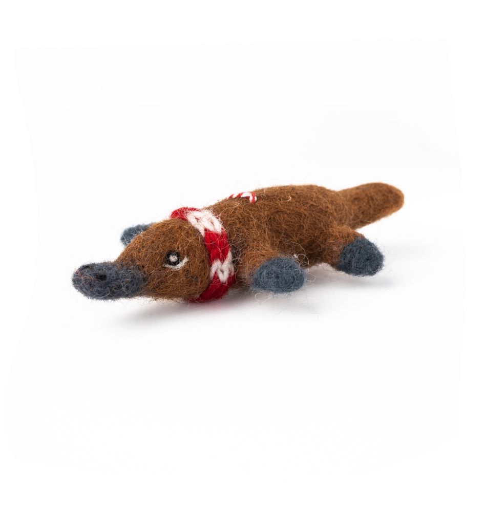 Felted platypus hanging Christmas decoration in brown with a red scarf on a white background