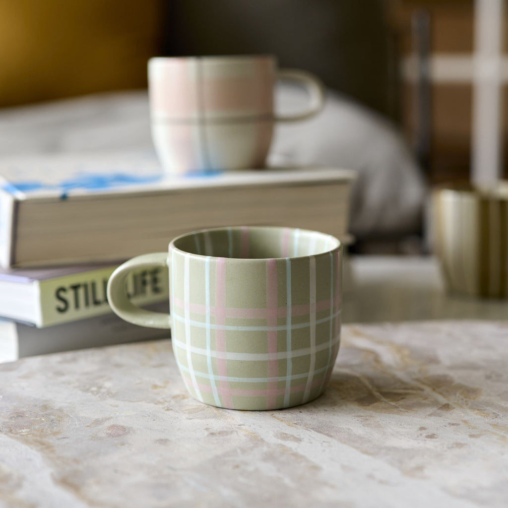 Twig and Feather - The Cat's Pyjamas mug in sage and blush check - by Robert Gordon - shown near books on coffee table