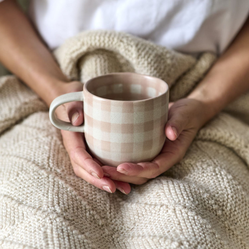 Twig and Feather - The Cat's Pyjamas mug in soft terracotta or dusty pink in a gingham check pattern - by Robert Gordon - being held by lady